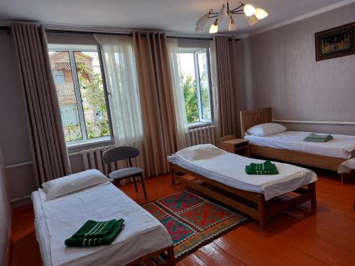 a room with two beds and two windows at Nomad 114 in Balykchy