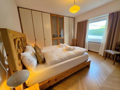 a bedroom with a wooden bed with a large window at Splendida dimora vista lago in St. Moritz