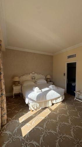 a bedroom with a large bed with white sheets at Hôtel Château de la Tour Cannes in Cannes