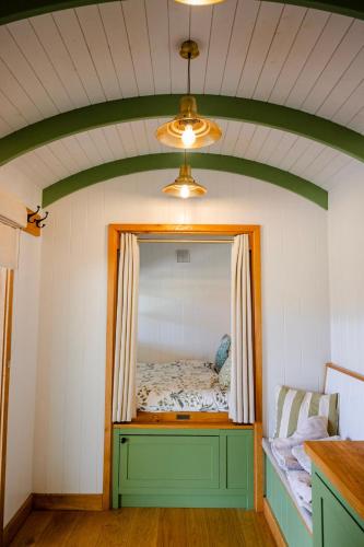 a bedroom with a mirror and a bed in it at Northcombe Farm Shepherd's Hut in Germansweek