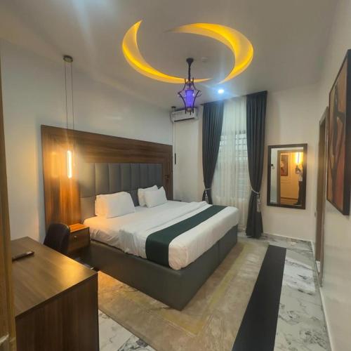 a bedroom with a large bed and a chandelier at Classy Castle Hotel and Suite in Orho Agbarho