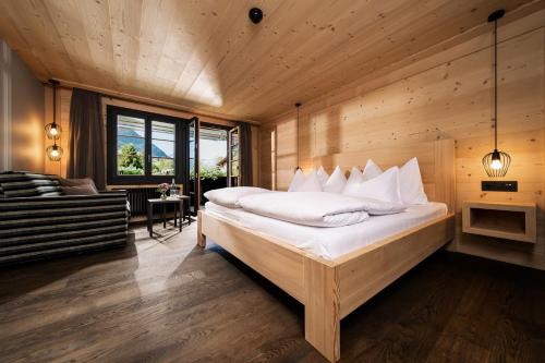 a bedroom with a large bed in a wooden room at Hotel Arc-en-ciel Gstaad in Gstaad