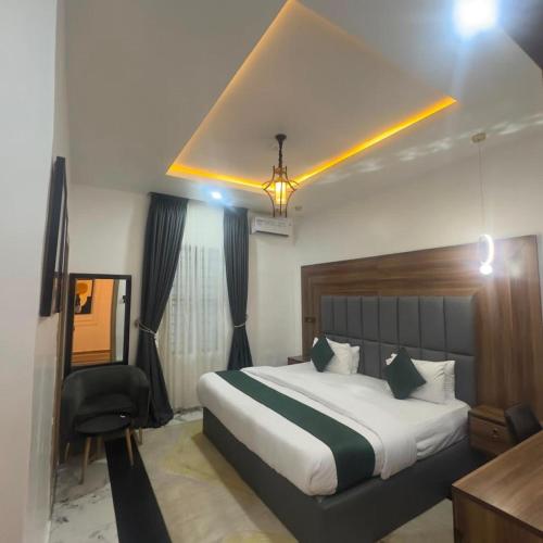 a hotel room with a bed and a chair in it at Classy Castle Hotel and Suite in Orho Agbarho