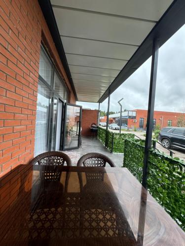 a patio with two chairs and a table on a building at Alfa white resort in Koshkolʼ