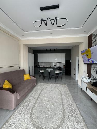 a living room with a couch and a dining room at Alfa white resort in Koshkolʼ
