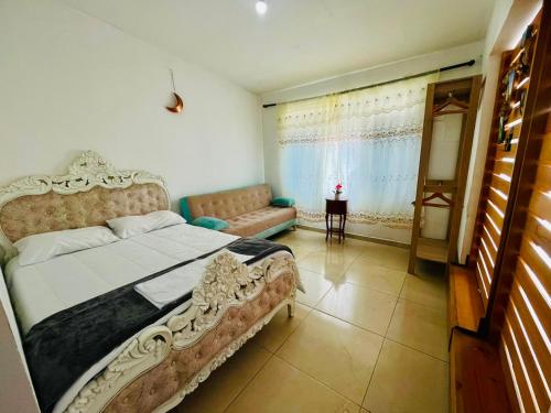 a bedroom with a large bed and a couch at Casa Hostal los Profes in Mocoa