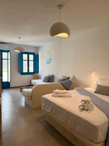 a hotel room with two beds and a couch at Apollonia Studios in Katapola