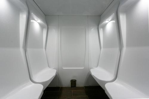 a bathroom with three white urinals in a room at Hotel Ponta Delgada in Ponta Delgada