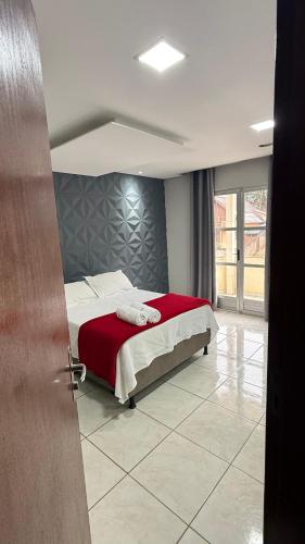 a bedroom with a bed with a red blanket at LUZ DO LUAR in Pedra Azul