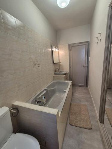 a bathroom with a large tub and a toilet at L'Ostal De Papi in Saint-Affrique