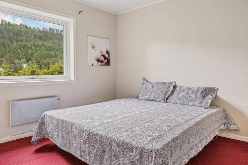 a white bedroom with a bed and a window at Lobrothaugen in Fagernes