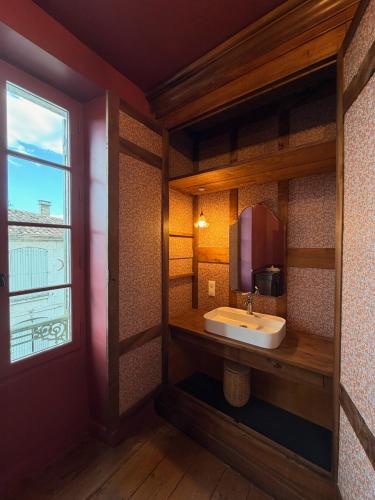 a bathroom with a sink and a window at La Maison Colette - B&B in Issigeac