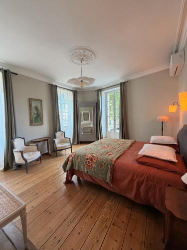a bedroom with a large bed and a living room at La Maison Colette - B&B in Issigeac