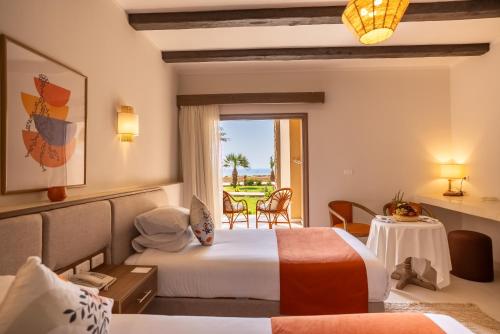 a hotel room with two beds and a window at Shams Alam Beach Resort in Marsa Alam City