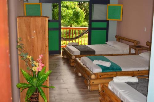 a room with four beds and a balcony at Finca Hotel Loma del Café in Pueblorrico