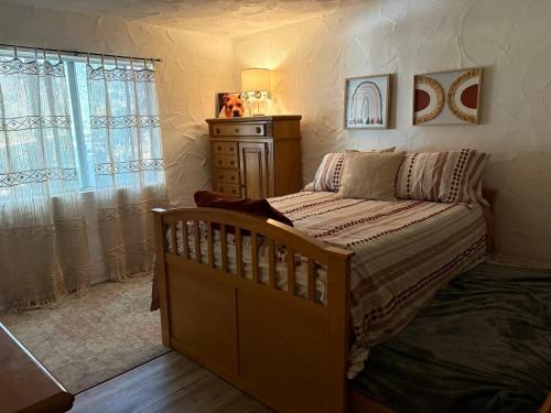 a bedroom with a bed and a dresser and a window at Wolf Den retreat on 20 acres in Julian