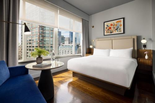 a bedroom with a white bed and a table and window at ModernHaus SoHo in New York