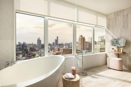 a bathroom with a bath tub and a large window at ModernHaus SoHo in New York