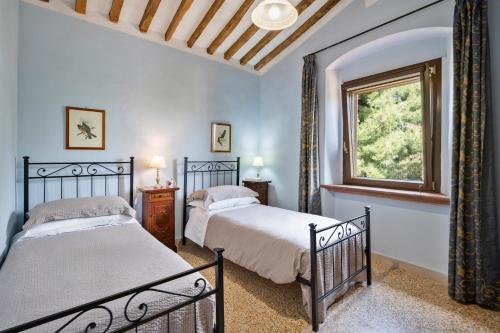 two beds in a bedroom with a window at Il Martellino in Follonica