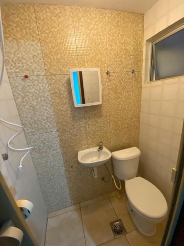 a small bathroom with a toilet and a sink at Apto MAR AZUL CARIBE - PRAIA DO FORTE - 3 minutos a pé da praia in Cabo Frio