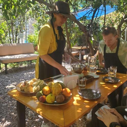 a woman standing at a table with food on it at Pakakuna in Urubamba