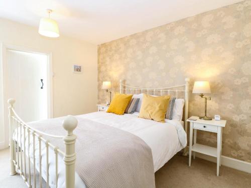 a bedroom with a white bed with yellow pillows at 19 Covert Road in Southwold