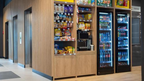 a grocery store aisle with two refrigerators and drinks at B&B HOTEL Kielce Centrum in Kielce