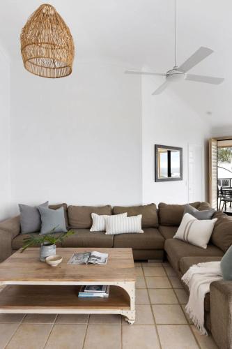 a living room with a couch and a coffee table at Penthouse with Incredible Views & Pool in Noosa Heads