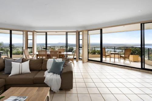 a living room with a couch and a table at Penthouse with Incredible Views & Pool in Noosa Heads