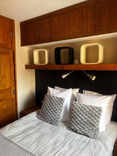 a bedroom with a bed with two monitors above it at Tania nice chalettt garden view in Courchevel