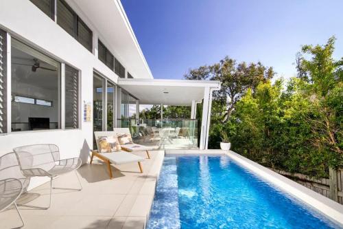a swimming pool in the backyard of a house at Stunning Views, Private Pool Near Hastings St in Noosa Heads