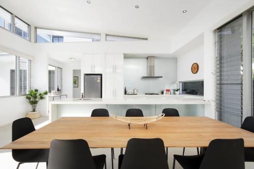 a dining room and kitchen with a table and chairs at Stunning Views, Private Pool Near Hastings St in Noosa Heads