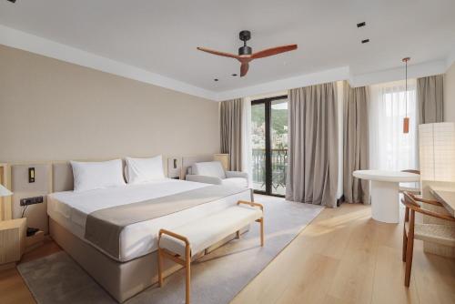 a bedroom with a large white bed and a table at Viale in Budva