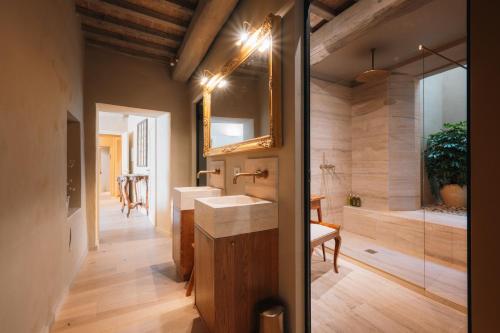 a bathroom with two sinks and a mirror at Palazzo Lucchini in Montalcino