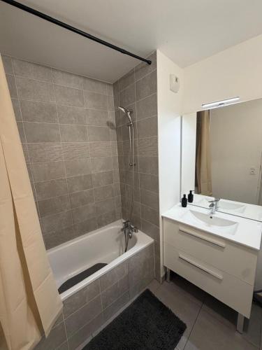 a bathroom with a tub and a sink and a bath tub at Modern 2BR Train, Versailles, Paris in Plaisir