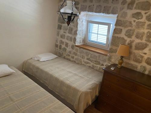 a bedroom with two beds and a window at Stoun house in Reževići