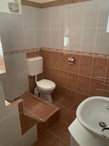 a bathroom with a toilet and a sink at Stoun house in Reževići