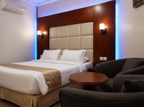 a hotel room with a large bed and a couch at سرايا الغربية للشقق المخدومة - saraya algharbiyya Establishment in Jeddah