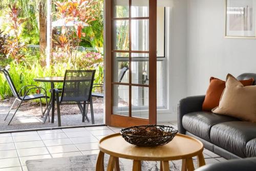 a living room with a couch and a table at Riverside Rest on Noosa River in Noosaville