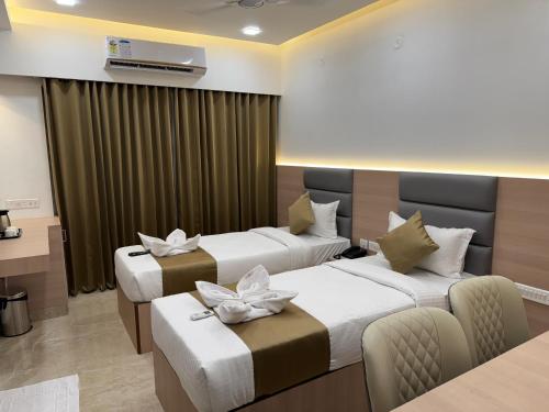a hotel room with two beds with flowers on them at Grand Silver in Chennai