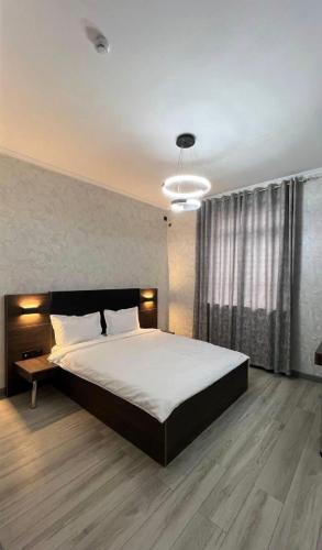 a bedroom with a large bed and a large window at Van park hotel in Shymkent