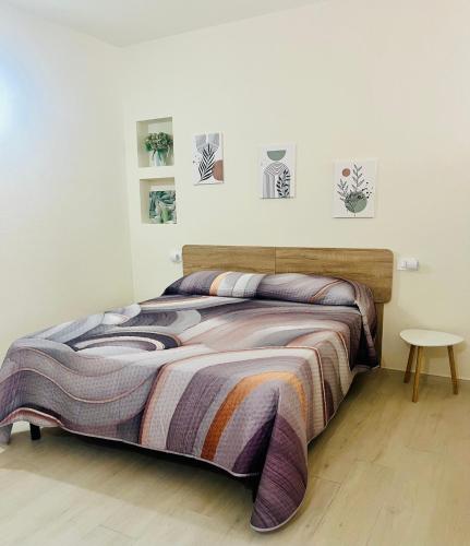 a bedroom with a bed with a blanket and a table at La casetta in Teulada