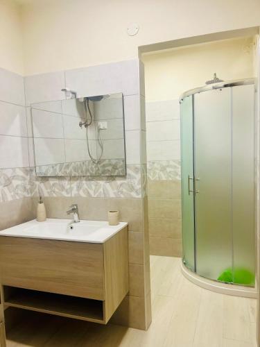 a bathroom with a sink and a glass shower at La casetta in Teulada