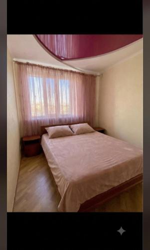 a small bedroom with a bed and a window at Bright House in Bila Tserkva