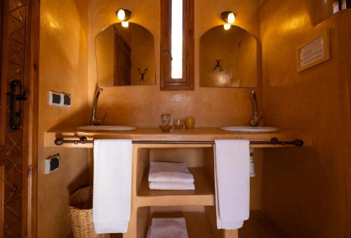 a bathroom with two sinks and two mirrors at Paradis Nomade in Azrarag