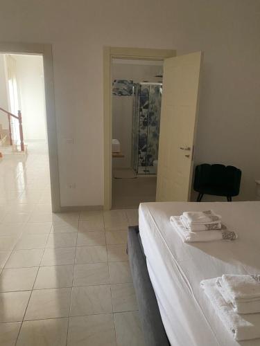 a white room with a bed and a bathroom at Dietro La Torre in Lizzano