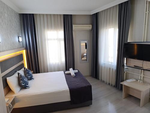 a bedroom with a bed and a flat screen tv at Çiçek Hotel in Ankara