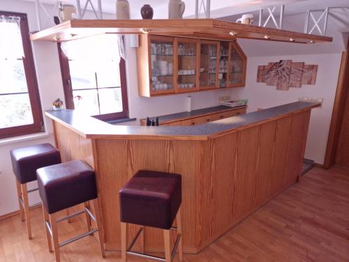 a kitchen with a large wooden bar with stools at Ferienwohnung Seiffener Hof in Seiffen