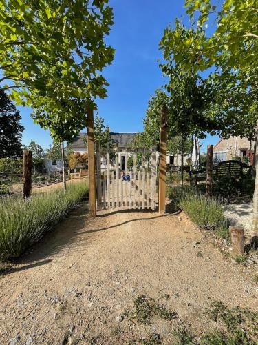 a gate to a cemetery with trees and grass at A la terre ferme in Arnac-la-Poste