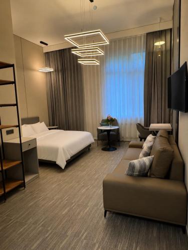a hotel room with a bed and a couch at Wind Rose in Almaty